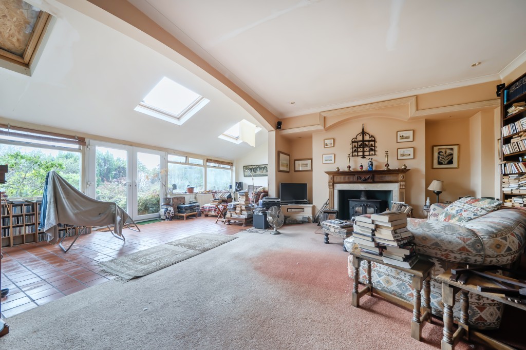 Lot: 47812 - FORMER CAPTAINS HOUSE PLUS THREE-BEDROOM BUNGALOW SET IN OVER 8.5 ACRES OF LAND WITH COUNTRYSIDE AND SEA VIEWS - Living room opening into sun lounge